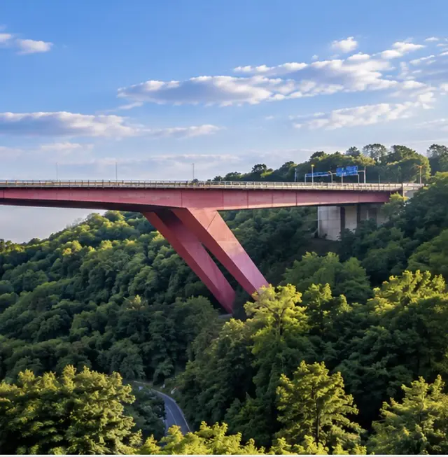 Right third of the red bridge rising over the wooded valley, symbolising mission